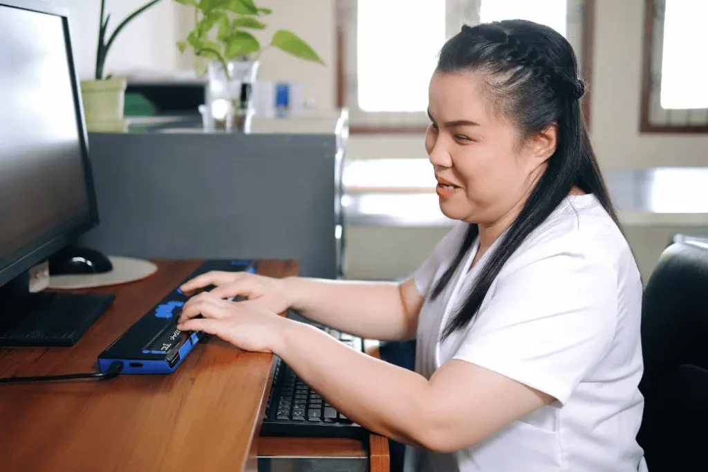 Blind woman using laptop and smiling